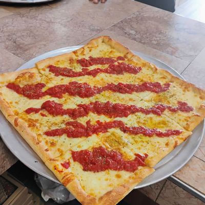 Rectangular pizza topped with stripes of red sauce